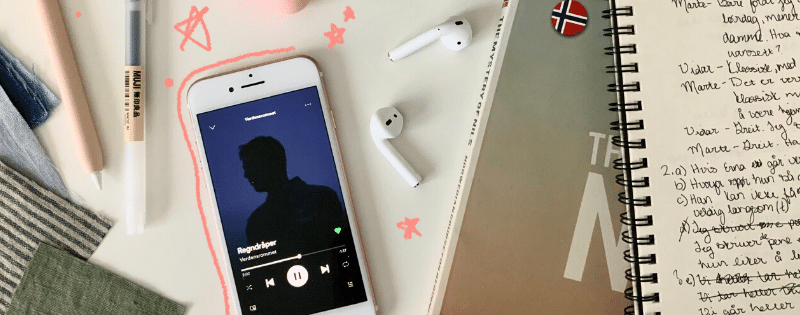 Study desk with an iphone showing Norwegian music on it.