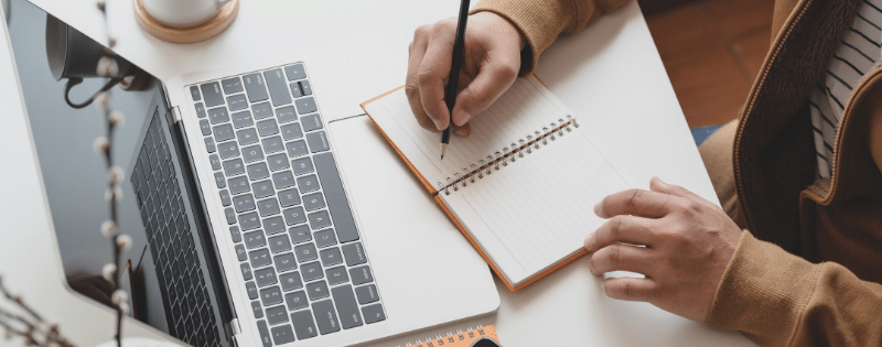 man writing in a notebook